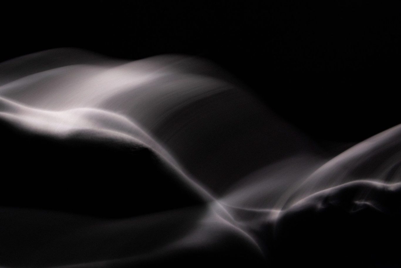 Impressionist figurative photography showing an ethereal study of human form and shadow with soft focus, painterly aesthetic. 